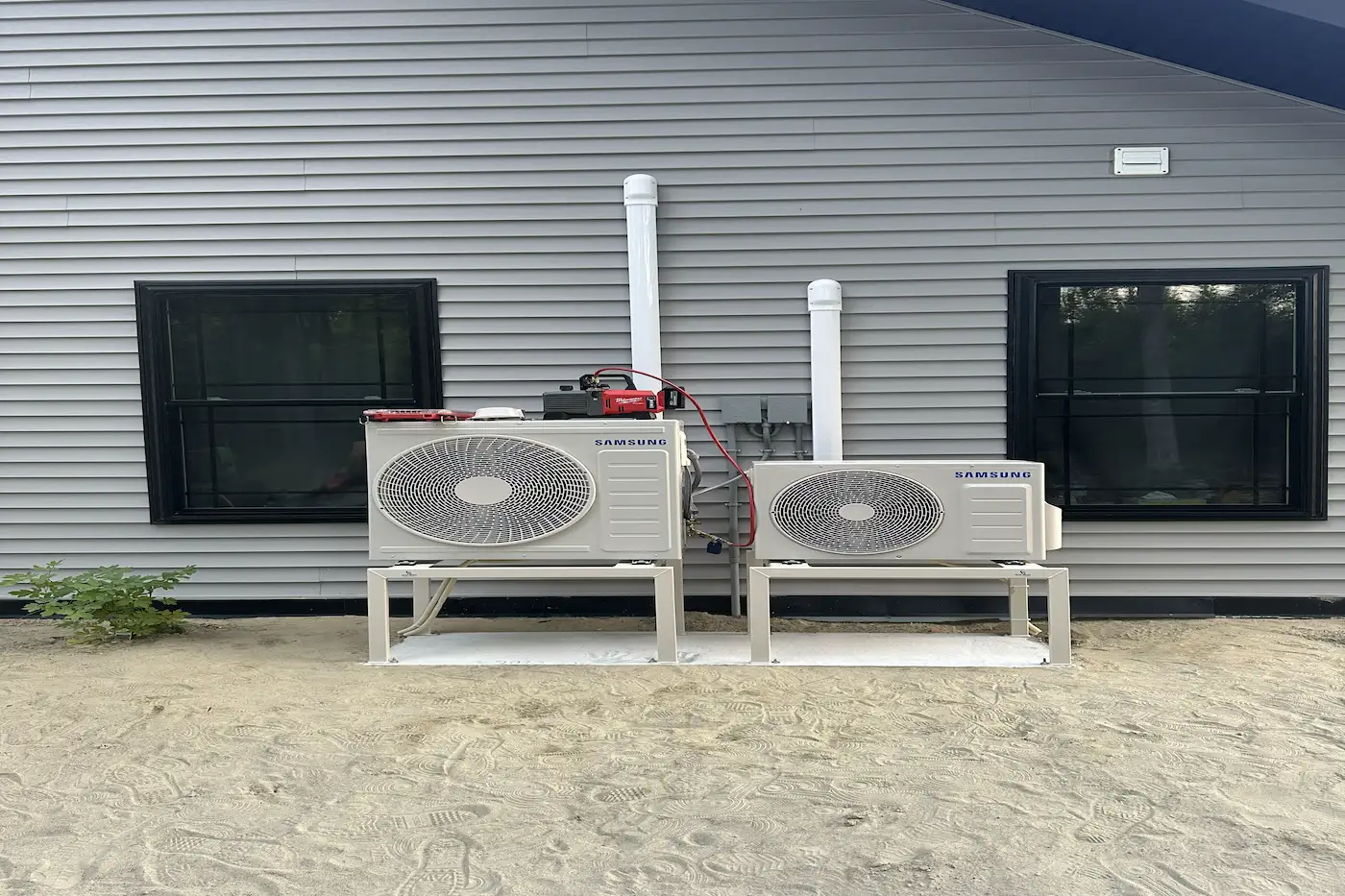 Ductless heat pump outdoor condenser unit installed on exterior wall brackets in Maine